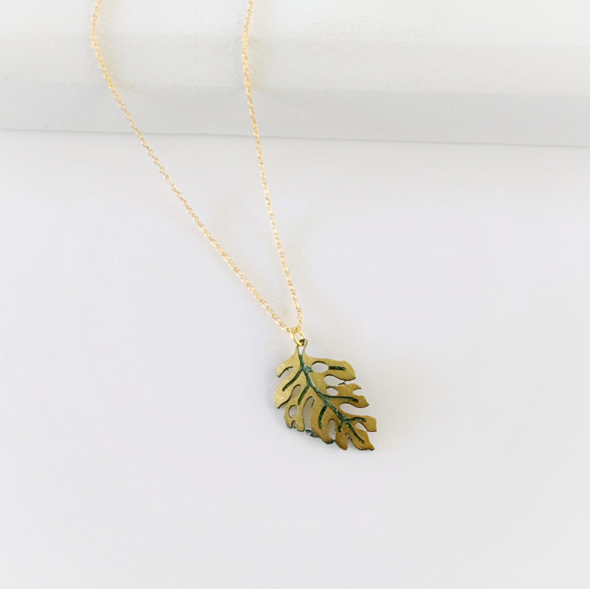 Leighton Lam Designs Monstera Patina Holiday Set featuring festive green and bronze-toned botanical accessories.