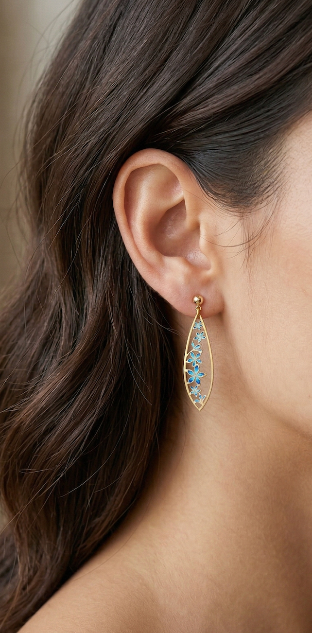 close up of a plumeria flower blue and gold earring